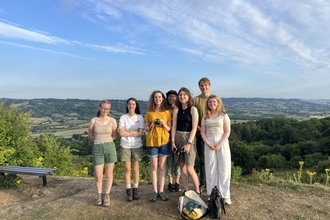 7 members of Youth Advisory Group at the top of Robinswood Hill looking towards the Cotswold escarpment