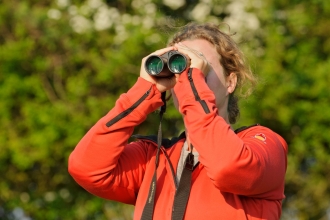 Young woman birdwatching at Rutland Water