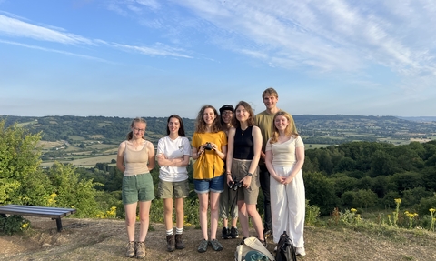 7 members of Youth Advisory Group at the top of Robinswood Hill looking towards the Cotswold escarpment