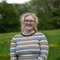 Cerys standing in a field with trees behind her