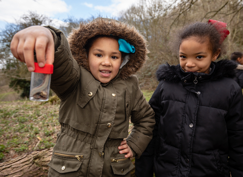 Two children looking at some wildlife in a specimen jar at Robinswood Hill