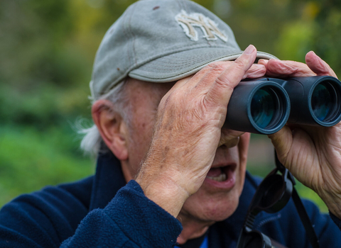 A man looking through binoculars