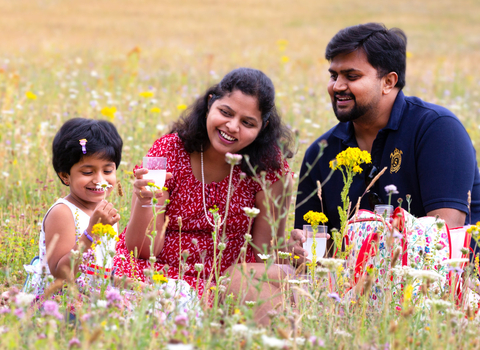 Family picnicking in wildflowers